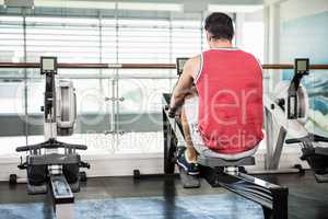 Muscular man on rowing machine