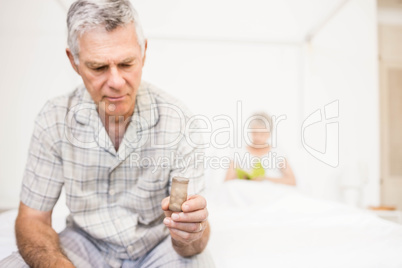 Suffering senior man taking pills