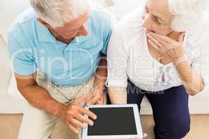 Focused senior couple using tablet