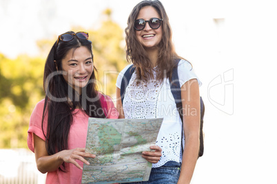 Hip friends holding map and looking at the camera