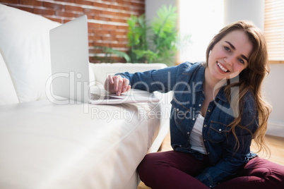 Pretty woman sitting on the floor using laptop