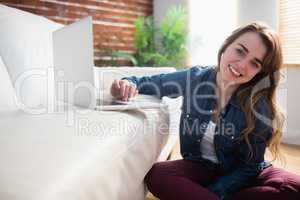 Pretty woman sitting on the floor using laptop