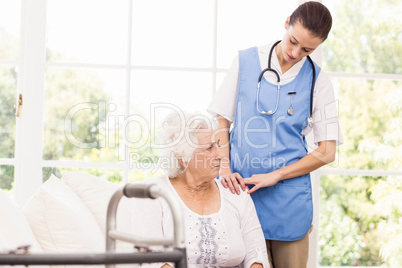 Nurse taking care of sick elderly woman