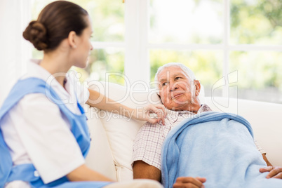 Nurse taking care of sick elderly patient