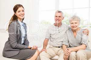 Smiling senior couple and businesswoman holding contract