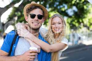 Hip couple embracing and smiling at the camera