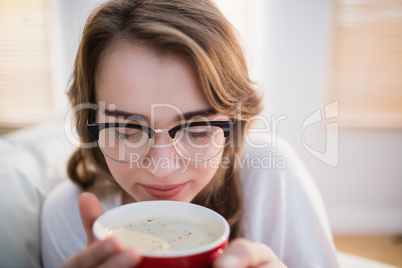 Pretty woman relaxing on couch with coffee