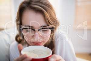 Pretty woman relaxing on couch with coffee