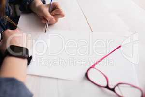 Businesswoman writing on sheet of paper