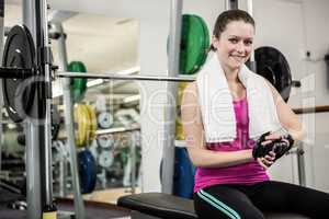 Smiling woman sitting on barbell bench
