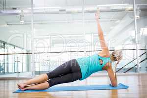 Fit blonde doing exercise on mat