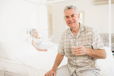 Peaceful senior man holding glass of water