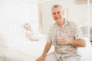 Peaceful senior man holding glass of water