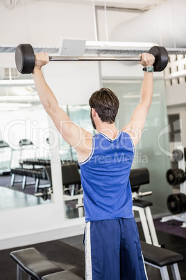 Muscular man lifting barbell