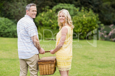 Happy couple holding picnic basket