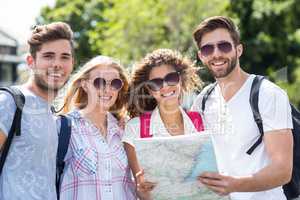 Hip friends holding map and looking at the camera