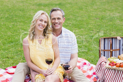 Happy couple having a picnic with wine