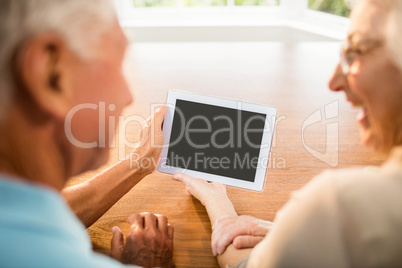 Rear view of senior couple using tablet