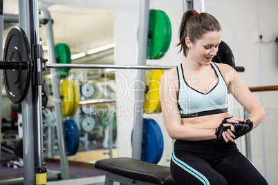 Smiling woman sitting on barbell bench