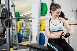 Smiling woman sitting on barbell bench