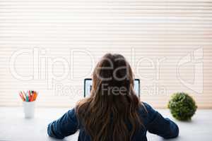 Rear view of hipster businesswoman using laptop