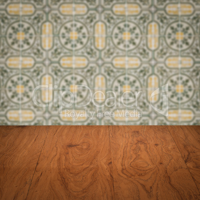 Wood table top and blur vintage ceramic tile pattern wall