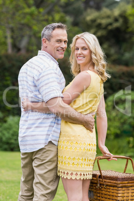 Happy couple holding picnic basket