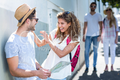 Hip couple holding map and laughing