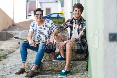 Hip men sitting on steps and looking at the camera