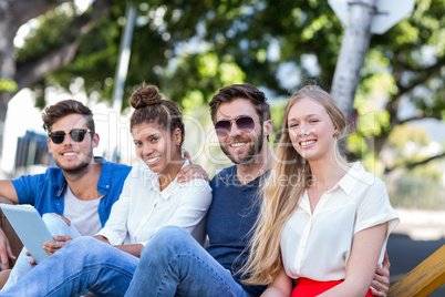 Hip friends holding tablet and smiling at the camera