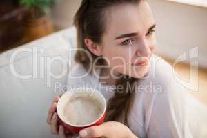 Pretty woman relaxing on couch with coffee