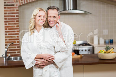 Cute couple cuddling in bathrobes