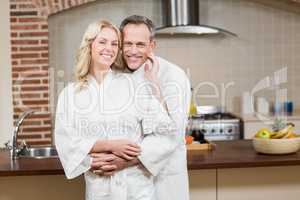 Cute couple cuddling in bathrobes