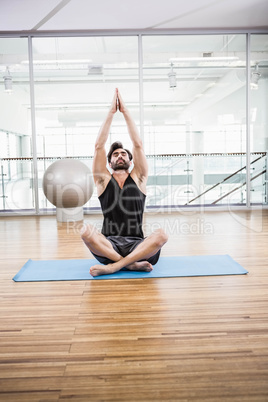 Handsome man doing yoga on mat