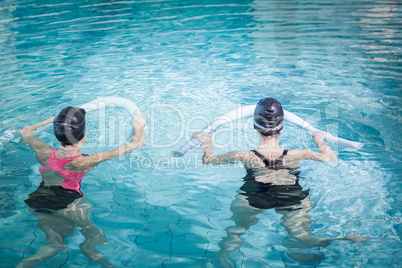 Women in the pool with foam rollers