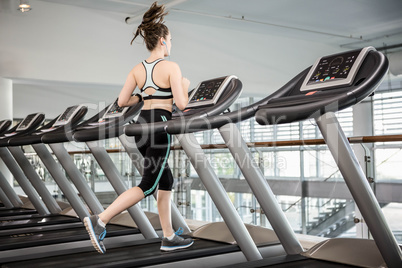 Fit brunette running on treadmill