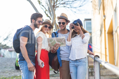 Hip friends taking pictures and checking map