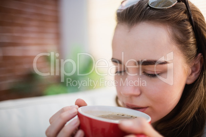 Pretty woman relaxing on couch with coffee