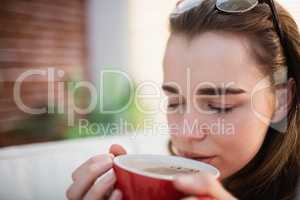 Pretty woman relaxing on couch with coffee