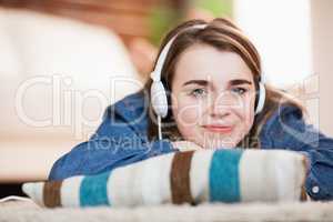 Pretty woman listening music lying on the floor