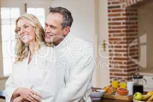 Cute couple cuddling in bathrobes