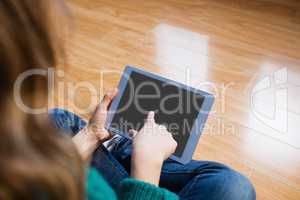 Woman sitting on the floor while using her tablet