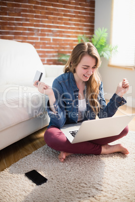 Pretty woman using her credit card to buy online