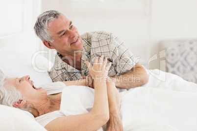 Happy senior couple at bed