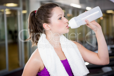 Fit woman drinking water from bottle