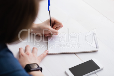 Casual businesswoman writing on notebooks