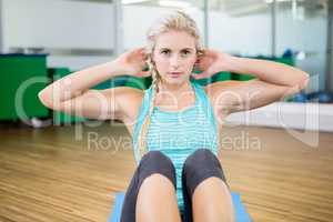 Fit blonde doing sitting up on mat