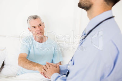 Handsome man nurse holding hand to senior man