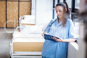 Nurse writing on a clipboard