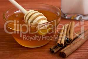Wooden honey stick and cinnamon sticks.